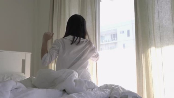 亚洲年轻女孩早上在卧室醒来。生活方式、家庭、教育和健康的概念。