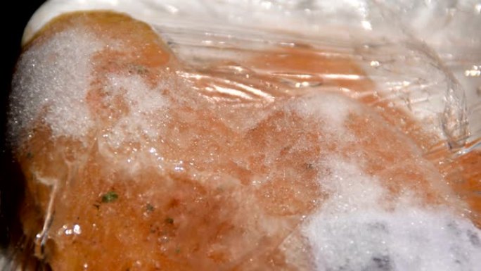 加速视频-塑料包装中的冷冻肉正在解冻