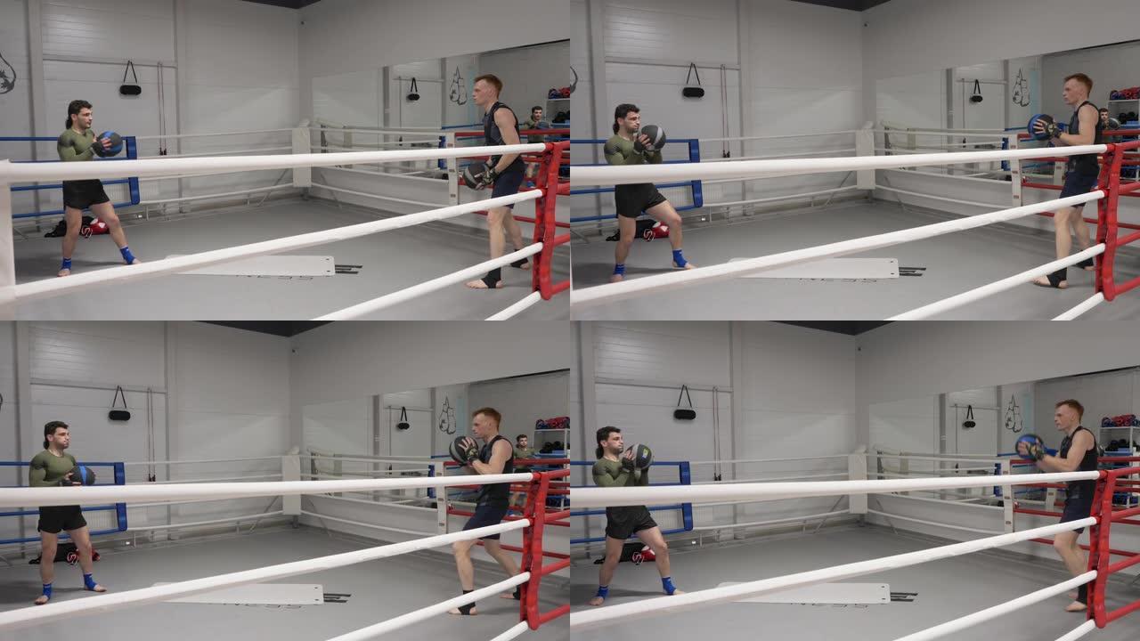 两个拳击手在拳击台上进行热身训练时投球。拳手拳击前在健身俱乐部由私人教练训练。