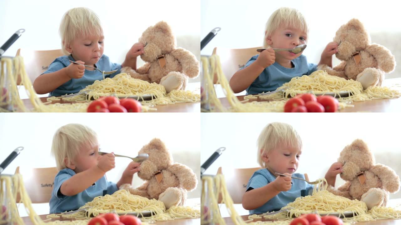 小男孩，蹒跚学步的孩子，午餐吃意大利面，家里一团糟，桌上摆着意大利面和西红柿