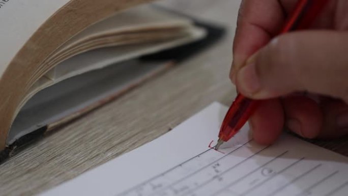 教师妇女用红笔干手在木桌上的成熟学生试卷上写F级和圈。关于成人教育和终身学习的想法。
