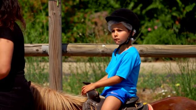 小男孩骑着小马玩耍