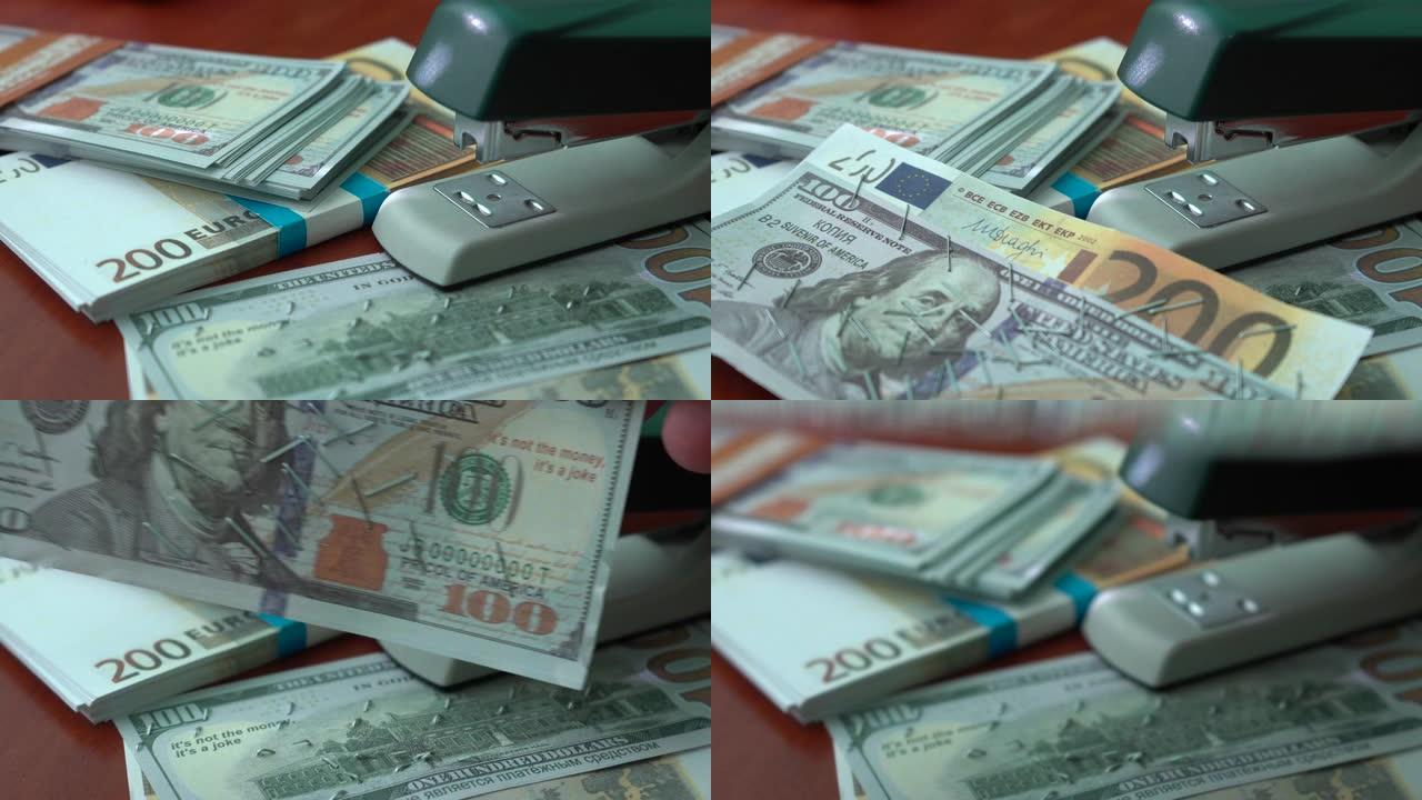 订书机用铁夹固定美元和欧元纸币。纸币背景上有回形针的订书机。假币