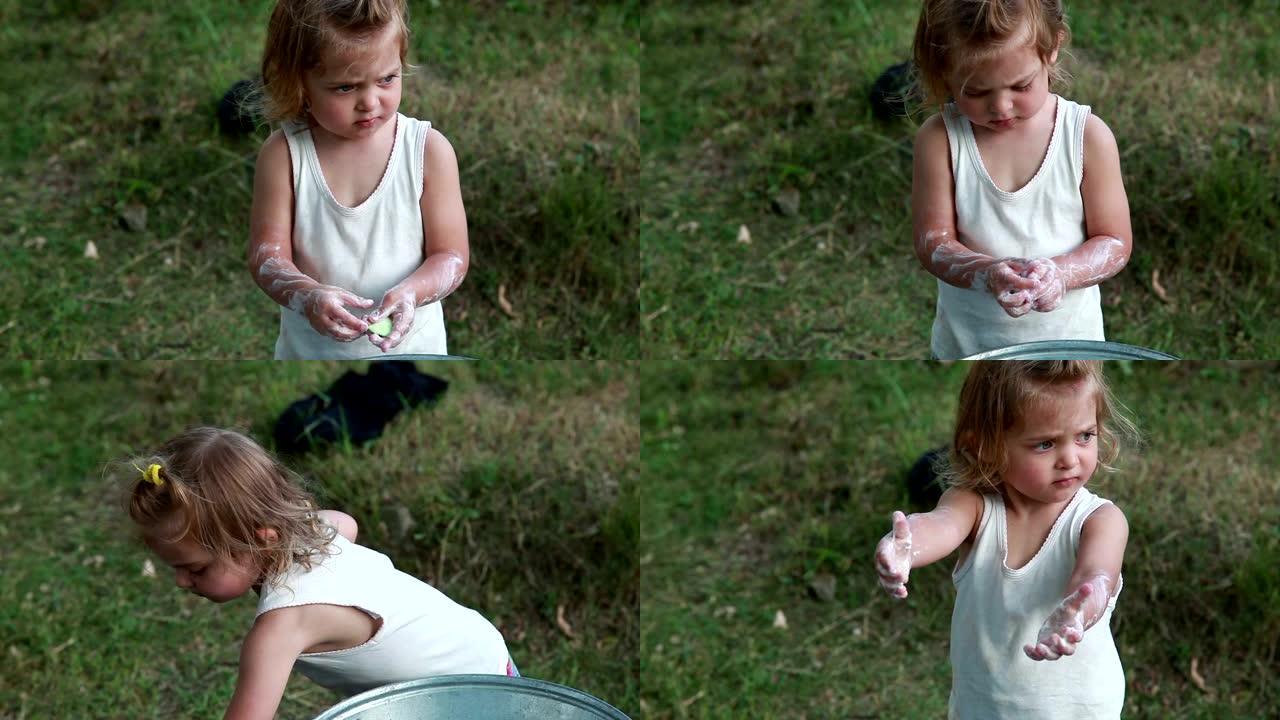 不悦的小女孩在后院洗手