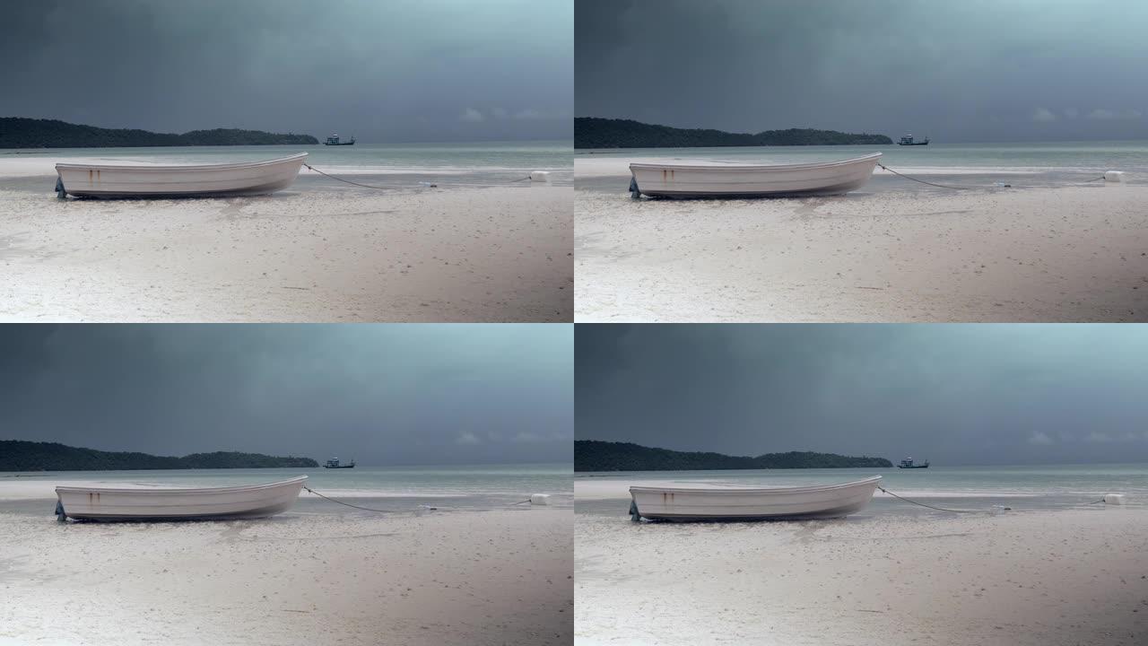 白色海滩上的一艘小船的特写镜头，背景中隐约可见黑暗的季风风暴