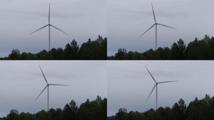 风车升起在森林之上，产生能量。4k慢速移动