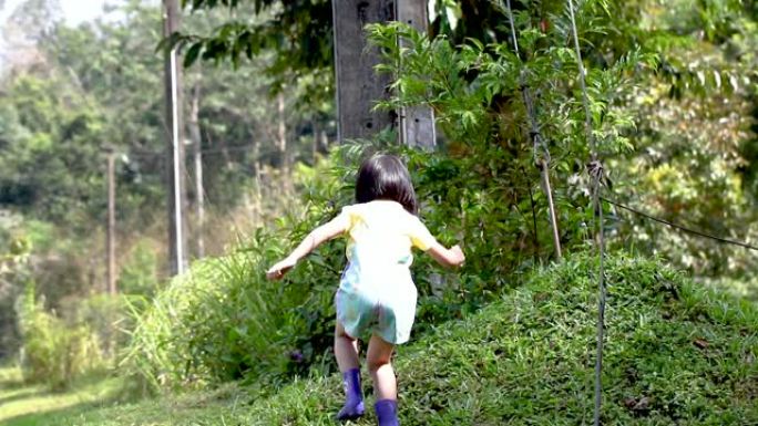 快乐的亚洲孩子在草地上跑步。将儿童与自然联系起来的概念。度假旅行。