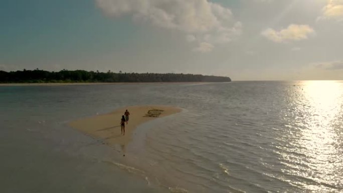 Balabac日落时在沙洲上行走的空中热带沙洲和海星和旅行夫妇