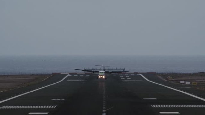 飞机降落在俯瞰海洋的跑道上
