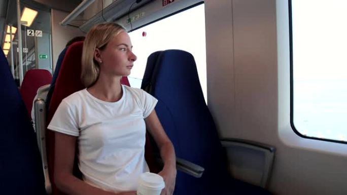 年轻女子坐在火车上看着窗外