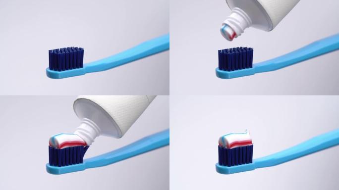 将三种颜色的牙膏从管子上挤压到牙刷上。孤立在白色背景上。特写。宏观。