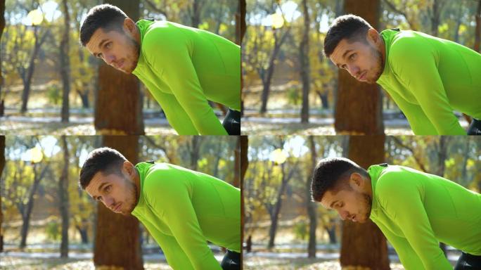 英俊的运动员在秋季公园慢跑后呼吸困难