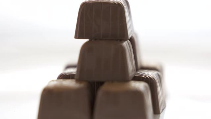 巧克力糖果金字塔旋转白色背景特写。