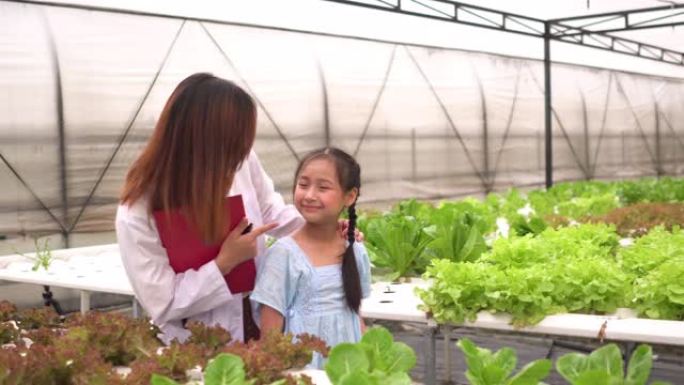 以下观点: 可爱的女孩去温室实地考察，科学家解释了有关疏水植物的知识