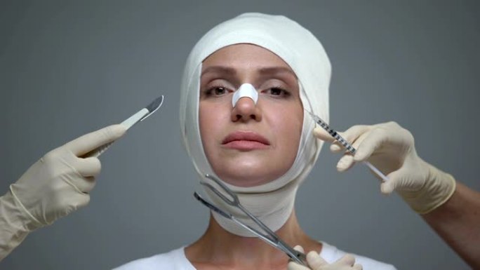 医生双手握着医疗设备靠近女性面部，进行整形手术