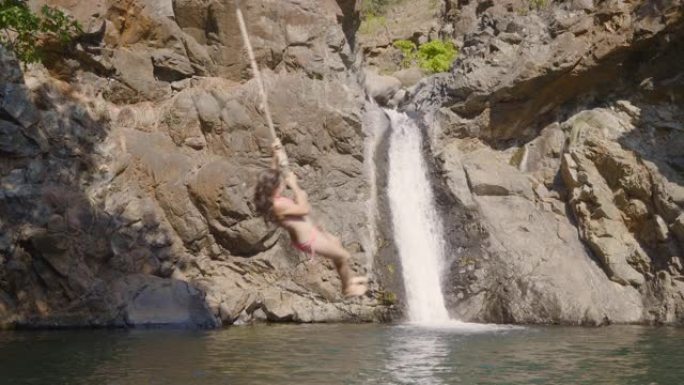 蹦极绳跳跃女孩夏季自然瀑布