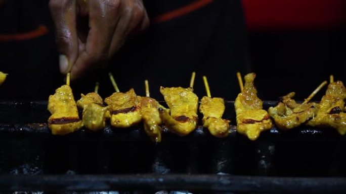 在热木炭烤架上烤猪肉，带烟熏，泰国街头小吃。