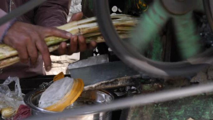 印度工人在印度的小型农村糖厂用甘蔗榨汁