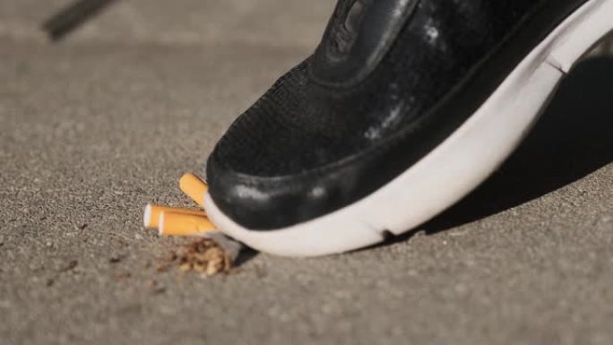 一名妇女在沥青上践踏香烟，停止吸烟，戒烟