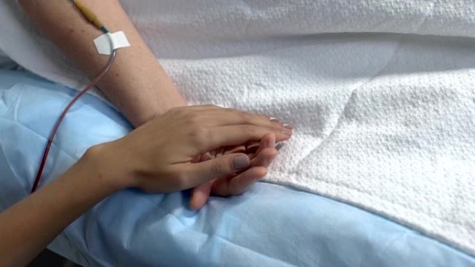 在医院病房中手握病妇女，疾病支持