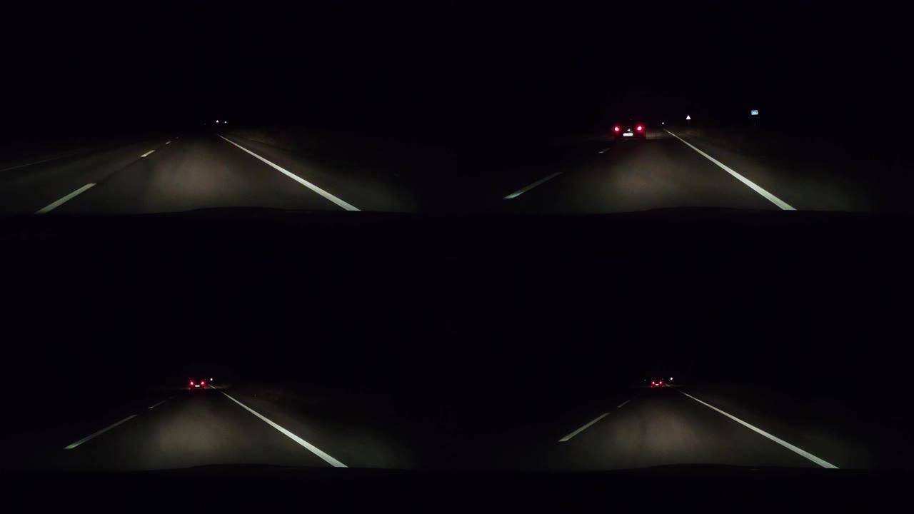 在夜间轨道上从出租车上观看。大灯照亮了汽车前面的沥青。迎面而来的车辆的前灯有时是可见的。在黑暗中安全