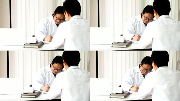 医疗保健概念。医生坐在办公室的桌子旁咨询病人。