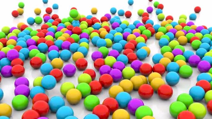 彩色小球落在地板镜头上。许多多色球体，糖果落在地上并弹跳快速动画。散布在视频周围的塑料装饰球体堆