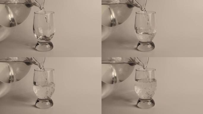 将来自jag的新鲜纯净水倒入白色背景的透明玻璃中。健康和饮食概念。水填充到透明玻璃中。慢动作镜头