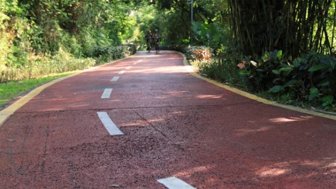 两个女性朋友在公园自行车道上骑行