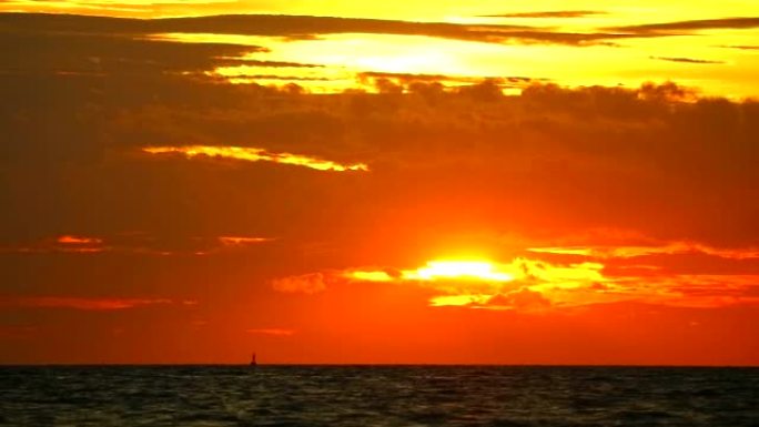 日落橙红色的天空和红色的云在海上移动