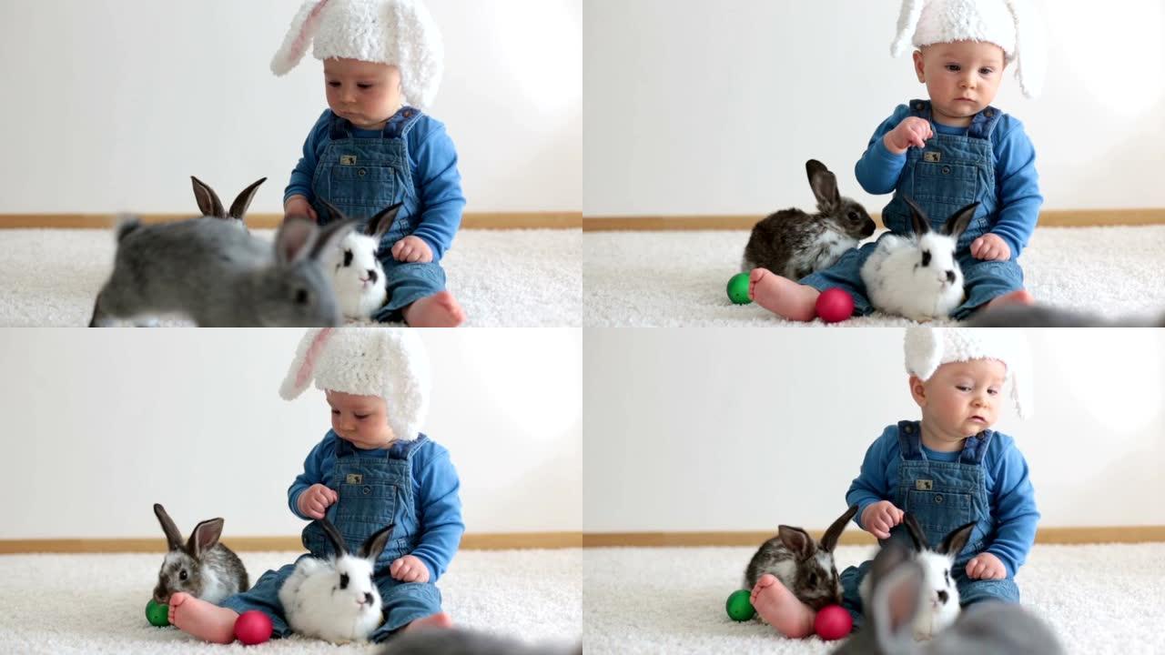 蹒跚学步的小孩，男婴，在家玩兔子和复活节彩蛋，彩蛋上的彩色手绘
