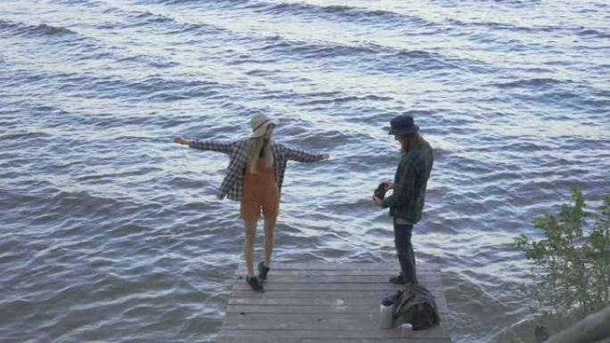 年轻的千禧一代旅游夫妇站在码头上，穿着格子衬衫