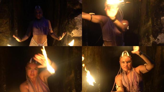 山洞里的女孩手里拿着火在危险地跳舞。