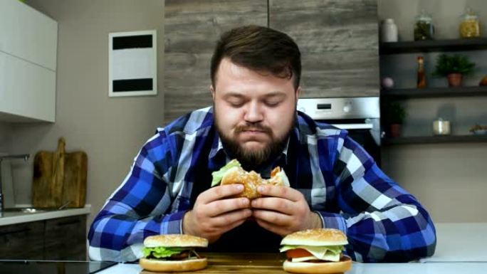 厚家伙吃他的汉堡，享受他的汉堡包。有胡子的人吃他煮的食物。不健康的生活方式，油炸和高热量有害食品。肥