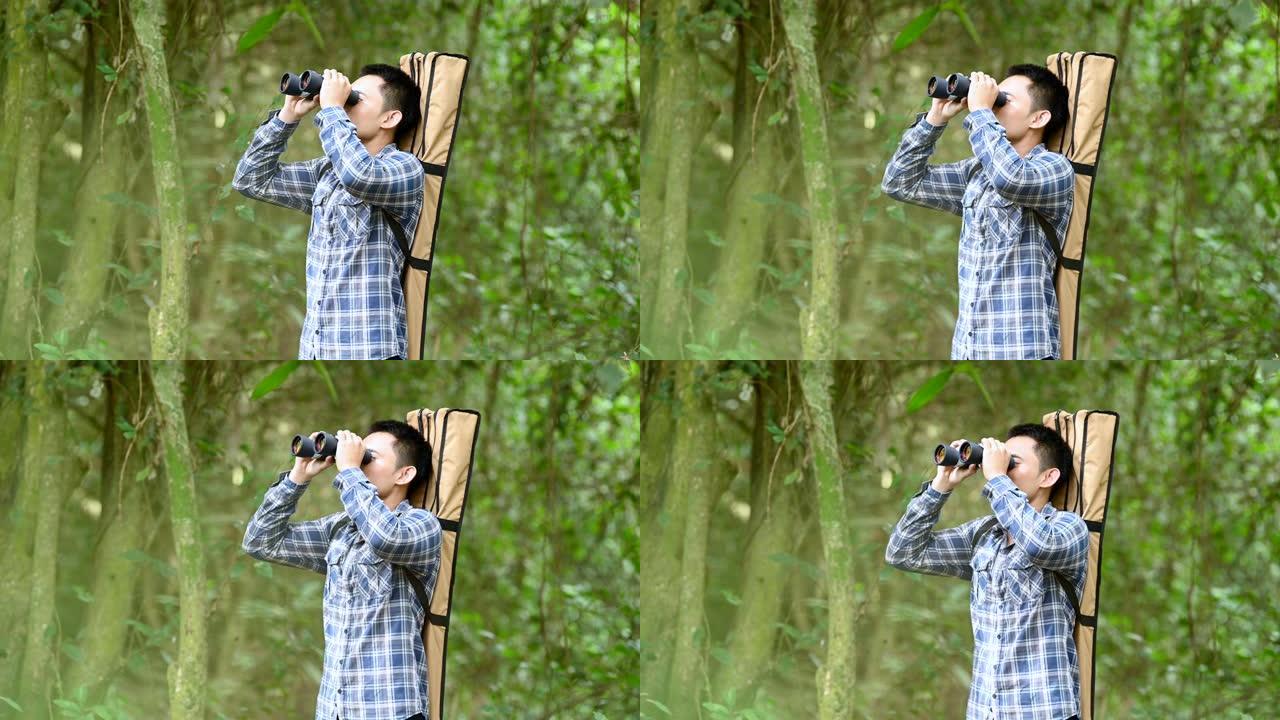 用双筒望远镜在森林里的人看起来像迷失的人或可预见的未来。人们的生活方式和休闲活动理念。自然和背包客旅