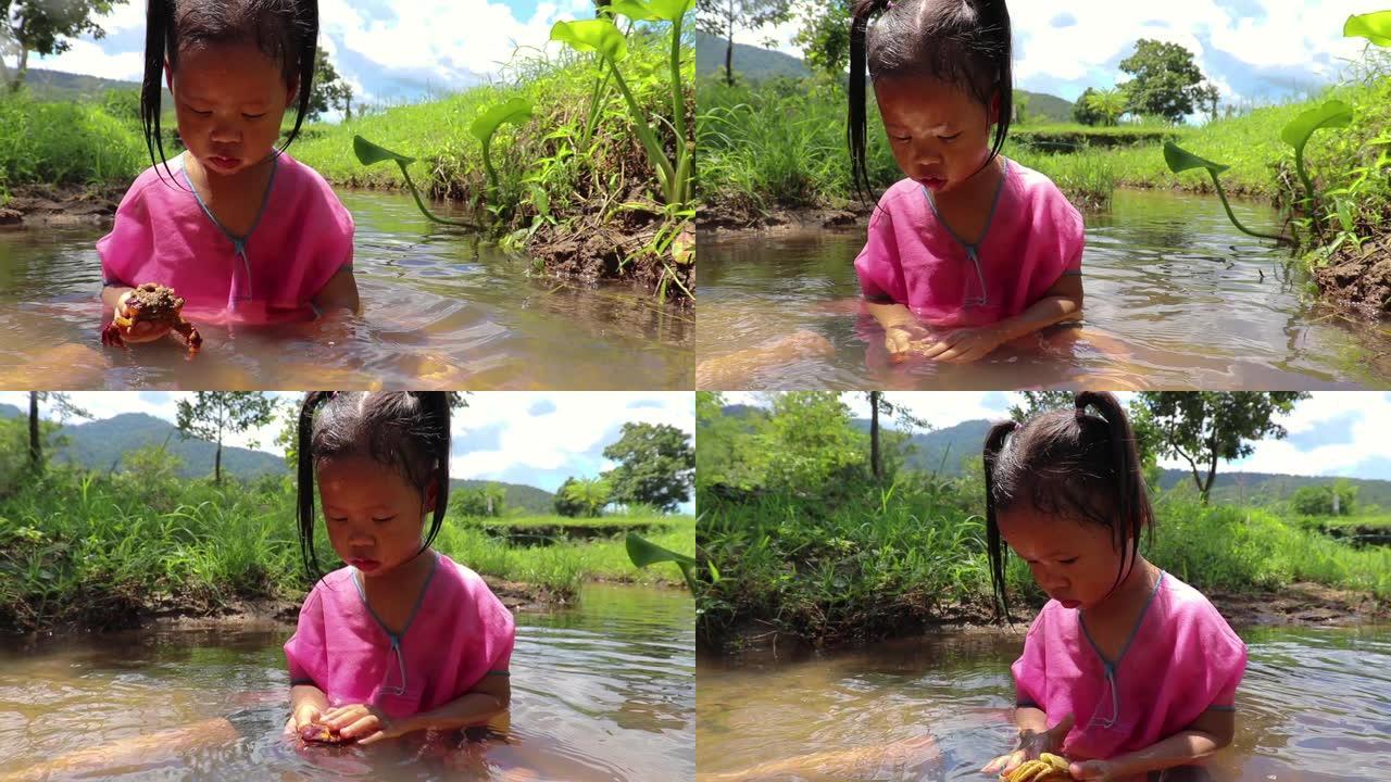 孩子们在溪水中赤脚玩耍，玩泥沙。