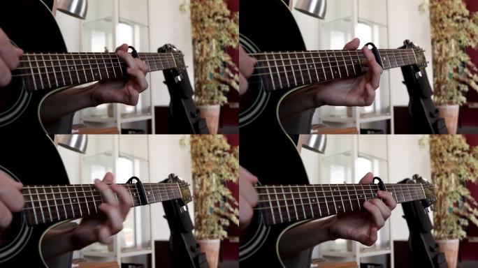 一个男人弹原声吉他的特写镜头。第6个品格上带有capo的手指采摘技术。