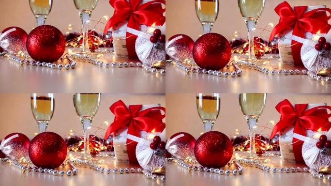 圣诞节。桌上摆着带起泡香槟的金杯。圣诞装饰品和蜡烛。节日内饰