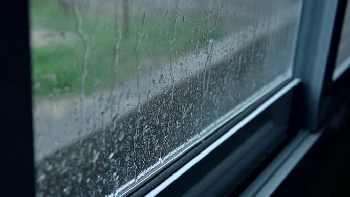 在下雨天，雨停在房子的窗户上。