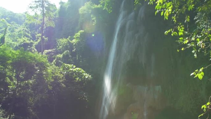 在深林茂密的绿叶和阳光中，令人惊叹的看不见的瀑布景色。萨拉武里亚洲泰国