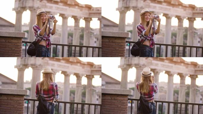 日出时，长发和蓝眼睛的快乐年轻金发女子在罗马论坛用老式相机拍照。意大利罗马