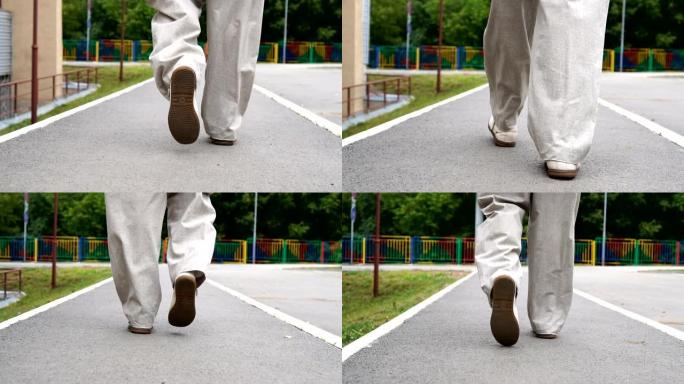 男人穿着鞋子在瓷砖路上行走的镜头。城市环境