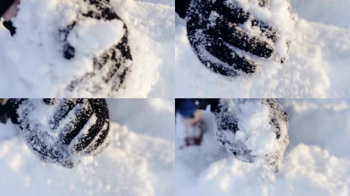 特写，戴着手套的手在阳光明媚的冬日打雪球