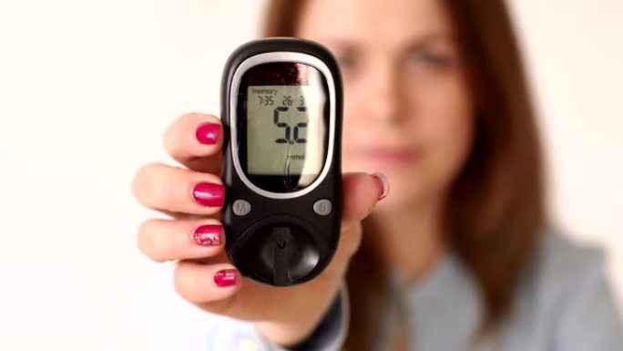 患有糖尿病的妇女持有血糖仪，血液中的葡萄糖水平很高