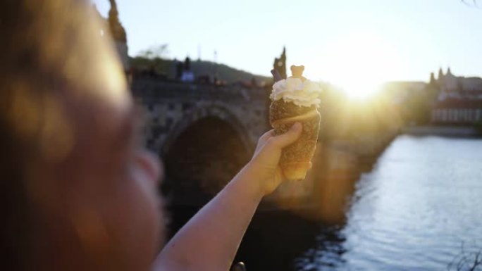 游客在布拉格的路堤上吃甜面包