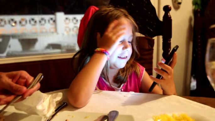 女孩在餐厅看手机吃饭