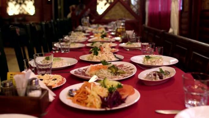餐厅或咖啡厅的餐桌上摆放着食物和沙拉，宴会桌上摆放着公司晚餐