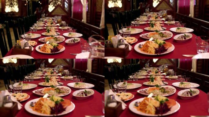 餐厅或咖啡厅的餐桌上摆放着食物和沙拉，宴会桌上摆放着公司晚餐