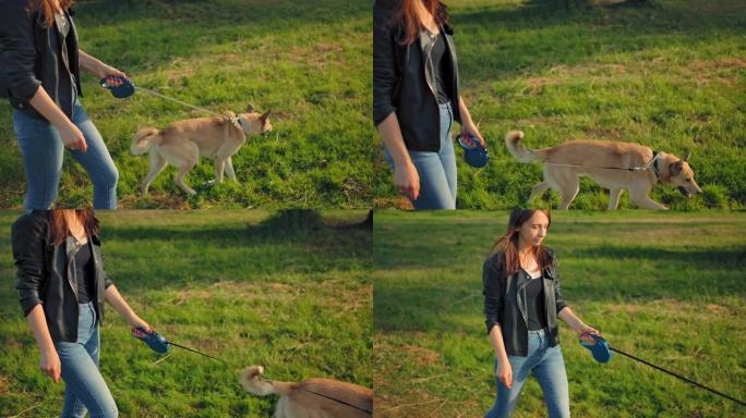 一名20岁的年轻女性牵着狗在公园里散步