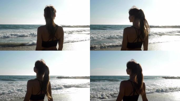 运动女子在海滩上放松身心，并在锻炼后欣赏美景